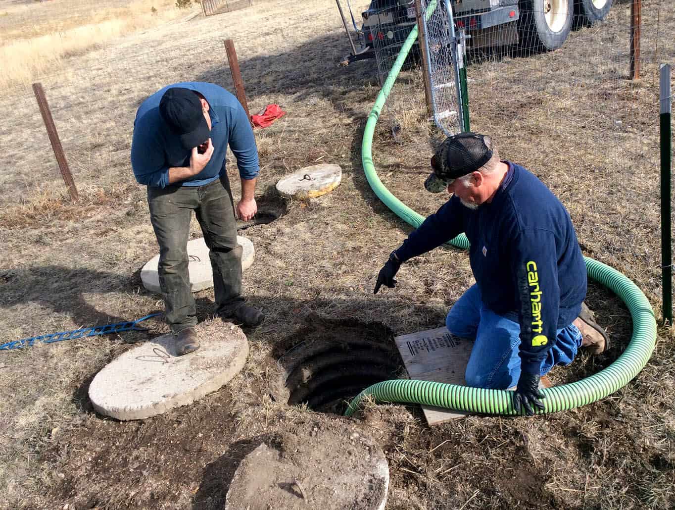 2 men repairing a septic tank